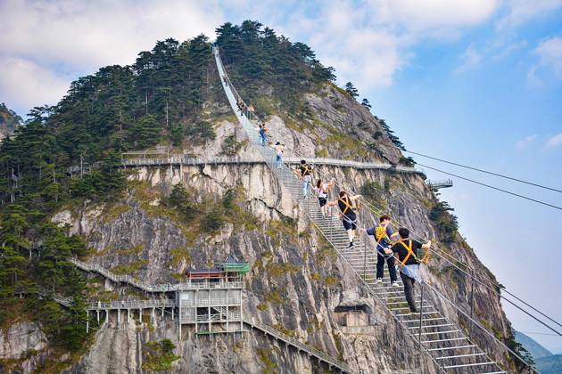 China Sky Ladder Challenger Tourists climb up a 250-meter-long soft ladder between two mountains in Mingtangshan Scenic Area in Yuexi county in central China s Anhui province, Sunday, Oct. 11, 2026. The rope ladder has 620 steps and a vertical distance of 365 meters. It opened to tourists in June this year, and quickly became a tourist attraction., Credit:stringer Utuku Feature China Avalon CHINA, ANHUI, YUEXI Copyright: xstringerx xUtuku FeaturexChinax xAvalonx 1142342734