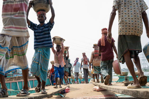 Migrant Workers Unload Sand Workers unload sand at a riverside site in Gabtoli, Dhaka, Bangladesh, on October 11, 2026. Many have left rural communities in search of employment in the capital, where daily labor provides a source of income but often involves strenuous work and limited financial security. Dhaka Bangladesh Copyright: xBipulxAhmedx originalFilename: mondol-notitle261011_npaLr