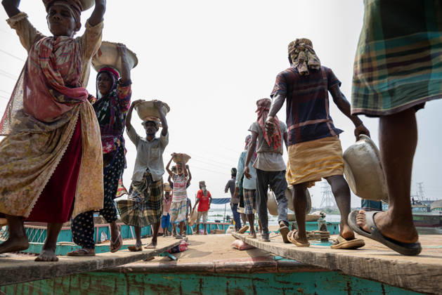 Migrant Workers Unload Sand Workers unload sand at a riverside site in Gabtoli, Dhaka, Bangladesh, on October 11, 2026. Many have left rural communities in search of employment in the capital, where daily labor provides a source of income but often involves strenuous work and limited financial security. Dhaka Bangladesh Copyright: xBipulxAhmedx originalFilename: mondol-notitle261011_npMc6