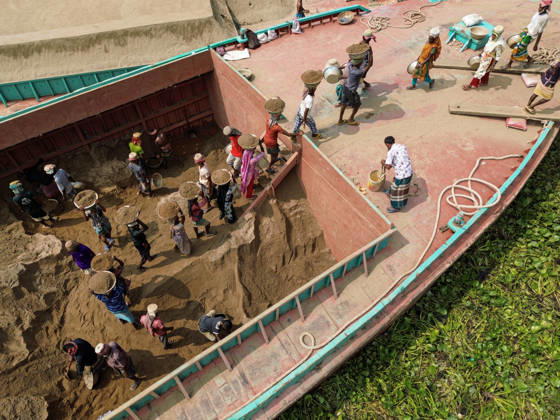 Migrant Workers Unload Sand Workers unload sand at a riverside site in Gabtoli, Dhaka, Bangladesh, on October 11, 2026. Many have left rural communities in search of employment in the capital, where daily labor provides a source of income but often involves strenuous work and limited financial security. Dhaka Bangladesh Copyright: xBipulxAhmedx originalFilename: mondol-notitle261011_npNve