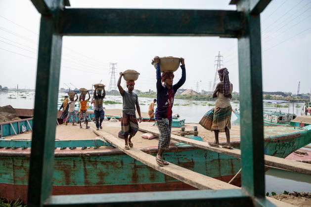 Migrant Workers Unload Sand Workers unload sand at a riverside site in Gabtoli, Dhaka, Bangladesh, on October 11, 2026. Many have left rural communities in search of employment in the capital, where daily labor provides a source of income but often involves strenuous work and limited financial security. Dhaka Bangladesh Copyright: xBipulxAhmedx originalFilename: mondol-notitle261011_npZmT