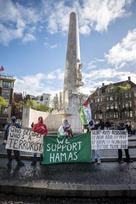 October 11, 2026, Amsterdam, North Holland, The Netherlands - Holland: 11 October 2026, Amsterdam, the Netherlands: Protesters hold pro-Hamas banners at the National Monument on The Dam. Protesters gathered at Dam Square for speeches and anti-war music before marching through AmsterdamÃ¢â‚¬â ¢s city centre in a demonstration dubbed Ã¢â‚¬oeThree Years of GenocideÃ¢â‚¬Â. The event marked three years since the start of the IsraelÃ¢â‚¬Hamas war. Demonstrators carried Palestinian flags and banners, demanding the Dutch government act against what they describe as a genocide in Gaza. Amsterdam The Netherlands - Holland - ZUMAp202 20261011_zip_p202_002 Copyright: xJamesxPetermeierx