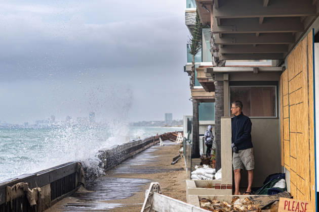 October 11, 2026, Long Beach, California, USA: Waves crash into the boardwalk along the Belmont Shore peninsula while a resident watches as remnants of Tropical Storm Rachel make their way through Southern California. Long Beach USA - ZUMAc316 20261011_znp_c316_003 Copyright: xEthanxCohenx