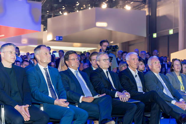 Berlin, 13.10.2026: Messe-Berlin-Chef Dr. Mario Tobias, der portugiesische Minister Goncalo Saraiva Matias, Bundesdigitalminister Karsten Wildberger und Bitkom-Präsident Ralf Wintergerst (2. bis 5. von links) verfolgen in der ersten Reihe das Bühnenprogramm der Smart Country Convention in der Halle hub27. Portugal ist Partnerland der Smart Country Convention 2026 und präsentiert dort seine Erfahrungen mit der Digitalisierung der öffentlichen Verwaltung. Ralf Wintergerst ist seit 2023 Präsident des Digitalverbands Bitkom. Dr. Mario Tobias ist Vorsitzender der Geschäftsführung der Messe Berlin. Karsten Wildberger ist seit Mai 2025 Bundesminister für Digitales und Staatsmodernisierung und leitet das damals neu geschaffene Ministerium,