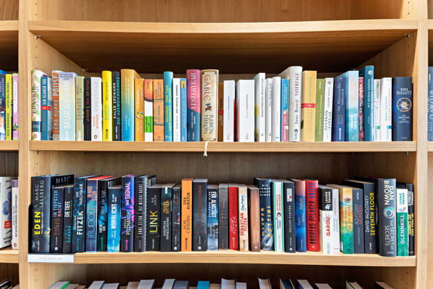 Berlin, 13.10.2026: Bücherregal mit Romanen und Krimis im neuen DKB-Campus in der Europacity in Berlin-Mitte; zum Campus gehört ein Literatur-CafÃ in Kooperation mit dem Kulturkaufhaus Dussmann. Gastronomie-, Kultur- und Veranstaltungsangebote sollen den Campus bewusst für das Quartier und die Stadtgesellschaft öffnen. Die Deutsche Kreditbank AG (DKB) hat ihren neuen Hauptsitz heute offiziell eröffnet. Der von Kleihues + Kleihues entworfene, rund 82 Meter hohe Komplex besteht aus drei Gebäudeteilen mit fünf, elf und 19 Geschossen und rund 35.000 Quadratmetern Mietfläche; entwickelt wurde er von der CA Immo unter dem Projektnamen Upbeat. Rund 2.600 Mitarbeitende des DKB-Konzerns, die bislang auf mehrere Berliner Standorte vert