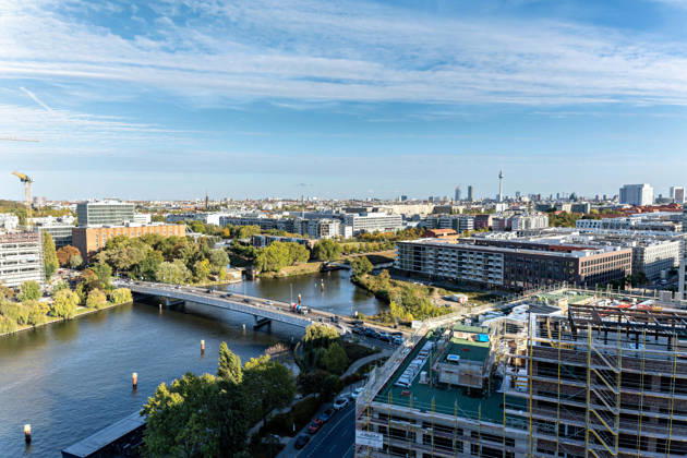 Berlin, 13.10.2026: Blick vom neuen DKB-Campus in der Europacity in Berlin-Mitte auf den Berlin-Spandauer Schifffahrtskanal, rechts Neubauten im Bau, am Horizont der Fernsehturm. Die Deutsche Kreditbank AG (DKB) hat ihren neuen Hauptsitz heute offiziell eröffnet. Der von Kleihues + Kleihues entworfene, rund 82 Meter hohe Komplex besteht aus drei Gebäudeteilen mit fünf, elf und 19 Geschossen und rund 35.000 Quadratmetern Mietfläche; entwickelt wurde er von der CA Immo unter dem Projektnamen Upbeat. Rund 2.600 Mitarbeitende des DKB-Konzerns, die bislang auf mehrere Berliner Standorte verteilt waren, arbeiten nun gemeinsam im Campus. Die DKB ist Exklusivmieterin und hat einen Mietvertrag über 15 Jahre abgeschlossen. DKB eröffnet ne