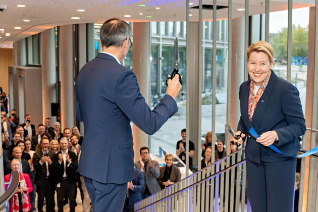 Berlin, 13.10.2026: DKB-CEO Dr. Sven Deglow (l.) hält nach dem symbolischen Banddurchschnitt die Schere in die Höhe, Berlins Bürgermeisterin und Senatorin für Wirtschaft, Energie und Betriebe, Franziska Giffey (SPD) (r.), lacht; die Gäste im Foyer des neuen DKB-Campus in der Europacity in Berlin-Mitte applaudieren. Die Deutsche Kreditbank AG (DKB) hat ihren neuen Hauptsitz heute offiziell eröffnet. Der von Kleihues + Kleihues entworfene, rund 82 Meter hohe Komplex besteht aus drei Gebäudeteilen mit fünf, elf und 19 Geschossen und rund 35.000 Quadratmetern Mietfläche; entwickelt wurde er von der CA Immo unter dem Projektnamen Upbeat. Rund 2.600 Mitarbeitende des DKB-Konzerns, die bislang auf mehrere Berliner Standorte verteilt