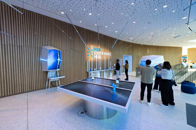 Berlin, 13.10.2026: Der DKB Experience Hub mit interaktiven Medientischen und Installationen im Foyer des neuen DKB-Campus in der Europacity in Berlin-Mitte. Die Deutsche Kreditbank AG (DKB) hat ihren neuen Hauptsitz heute offiziell eröffnet. Der von Kleihues + Kleihues entworfene, rund 82 Meter hohe Komplex besteht aus drei Gebäudeteilen mit fünf, elf und 19 Geschossen und rund 35.000 Quadratmetern Mietfläche; entwickelt wurde er von der CA Immo unter dem Projektnamen Upbeat. Rund 2.600 Mitarbeitende des DKB-Konzerns, die bislang auf mehrere Berliner Standorte verteilt waren, arbeiten nun gemeinsam im Campus. Die DKB ist Exklusivmieterin und hat einen Mietvertrag über 15 Jahre abgeschlossen. Gastronomie-, Kultur- und Veran