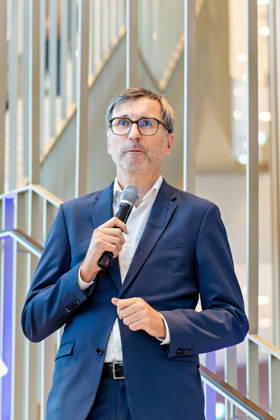 Berlin, 13.10.2026: DKB-CEO Dr. Sven Deglow spricht auf der Treppe im Foyer des neuen DKB-Campus in der Europacity in Berlin-Mitte zu den Gästen der Eröffnungsfeier. Die Deutsche Kreditbank AG (DKB) hat ihren neuen Hauptsitz heute offiziell eröffnet. Der von Kleihues + Kleihues entworfene, rund 82 Meter hohe Komplex besteht aus drei Gebäudeteilen mit fünf, elf und 19 Geschossen und rund 35.000 Quadratmetern Mietfläche; entwickelt wurde er von der CA Immo unter dem Projektnamen Upbeat. Rund 2.600 Mitarbeitende des DKB-Konzerns, die bislang auf mehrere Berliner Standorte verteilt waren, arbeiten nun gemeinsam im Campus. Die DKB ist Exklusivmieterin und hat einen Mietvertrag über 15 Jahre abgeschlossen. Die DKB unterstreicht mit d