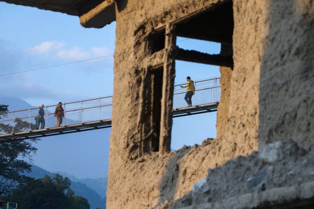 Nepal Bridge Restores Flood-Hit Access NUWAKOT, NEPAL, OCTOBER 14, 2026: Residents cross a newly built suspension bridge over the Trishuli River in Nuwakot, restoring access between communities affected by flash floods. Flooding destroyed bridges and damaged roads in the district, disrupting travel and access to essential services. NUWAKOT Nepal Copyright: x xShankarxBhujelx xJNAxPressx