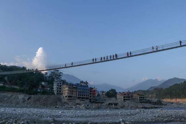 October 14, 2026, Nuwakot, Nepal: NUWAKOT, NEPAL, OCTOBER 14, 2026: Residents cross a newly built suspension bridge over the Trishuli River in Nuwakot, restoring access between communities affected by flash floods. Flooding destroyed bridges and damaged roads in the district, disrupting travel and access to essential services. Nuwakot Nepal  - ZUMAq101 20261014_zna_q101_127 Copyright: xShankarxBhujelx