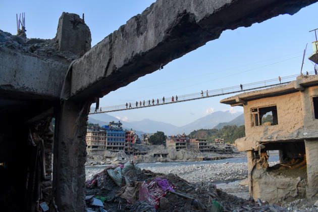 Aftermath of flash floods in Nepal NUWAKOT, NEPAL - OCTOBER 14 : People walk across a newly built suspension bridge over the Trishuli River, Nuwakot district, Nepal on October 14, 2026. Road and pedestrian connectivity has been restored with the construction of a new suspension bridge over the Trishuli River, allowing local residents to cross the river after the devastating floods damaged bridges and other infrastructure in the area. Sunil Pradhan Anadolu Nuwakot Nepal. Editorial use only. Please get in touch for any other usage.  Copyright: x2026xAnadoluxSunilxPradhanx