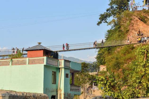 Aftermath of flash floods in Nepal NUWAKOT, NEPAL - OCTOBER 14 : People walk across a newly built suspension bridge over the Trishuli River, Nuwakot district, Nepal on October 14, 2026. Road and pedestrian connectivity has been restored with the construction of a new suspension bridge over the Trishuli River, allowing local residents to cross the river after the devastating floods damaged bridges and other infrastructure in the area. Sunil Pradhan Anadolu Nuwakot Nepal. Editorial use only. Please get in touch for any other usage.  Copyright: x2026xAnadoluxSunilxPradhanx
