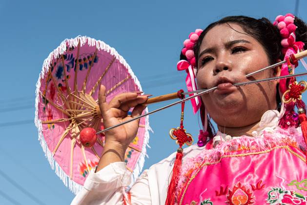October 15, 2026, Trang, Thailand: A devotee with a skewer piercing her cheek participates in a street procession during the Vegetarian Festival..The annual Vegetarian Festival is held in Bangkok and many parts of southern Thailand, including Trang, Phang Nga, and Phuket, where worshippers refrain from eating animal products over the nine days, coinciding with the celebration of the Nine Emperor Gods. Trang Thailand - ZUMAs197 20261015_aaa_s197_009 Copyright: xPeeraponxBoonyakiatx