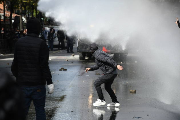 Student protests demanding improved educational conditions continue in Albania TIRANA, ALBANIA - OCTOBER 15: A masked protester crouches as a police water cannon sprays water toward demonstrators during the third day of protests demanding improved educational conditions in Tirana, Albania, on October 15, 2026. University students are joined by high school students and local residents as tensions escalate, with police using tear gas to disperse demonstrators outside the Ministry of Education and the Parliament building, while protesters throw stones and other objects at police officers. Olsi Shehu Anadolu Tirana Albania. Editorial use only. Please get in touch for any other usage.  Copyright: x2026xAnadoluxOlsixShehux