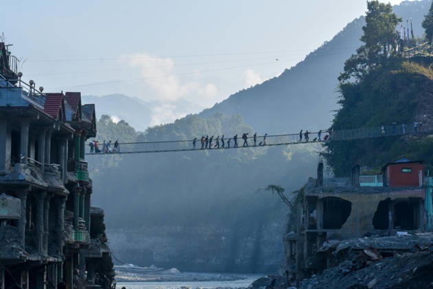 NUWAKOT, NEPAL - OCTOBER 15: Local residents cross the newly installed Bailey bridge connecting the border areas of Nuwakot and Rasuwa districts on October 15, 2026 in Nuwakot, Nepal. The bridge was installed to restore road connectivity after severe flooding destroyed existing bridges on August 26, 2026.  Copyright: xChinaxNewsxServicex 111674496442