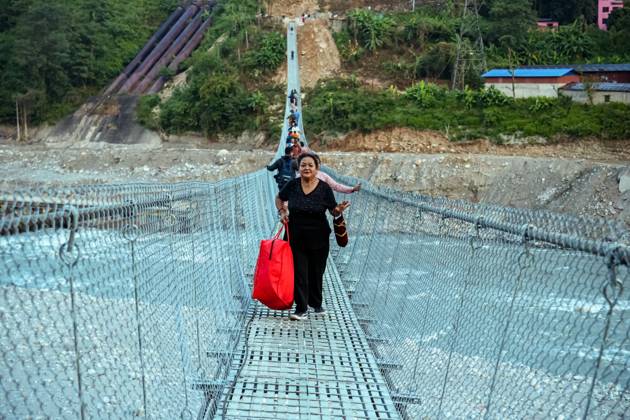New Bridge Restores Nuwakot Crossing NUWAKOT, NEPAL, OCTOBER 15, 2026: People cross a newly built suspension bridge over the Trishuli River in Bidur Municipality, Nuwakot District. The footbridge restores access between communities after flooding along the Bhotekoshi Trishuli river corridor swept away road bridges and disrupted local transport. NUWAKOT bagmati Nepal Copyright: x xAmbirxTolangx xJNAxPressx