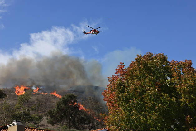 October16, 2026, San Juan Capistrano, California, USA: Fire crews are aggressively battling a wind-driven brush fire that burned several homes and threatened thousands of others in the area of San Juan Capistrano and San Clemente Friday, prompting evacuation orders. The Norte Fire exploded to 465 acres and remains 0 percent contained as of 4 p.m. O.C. Fire Authority officials said the Norte Fire started around 11:30 a.m. near Portico Del Norte and Eminencia Del Norte in San Clemente, east of Interstate 5. Fueled by strong Santa Ana winds, the wildfire then blew into neighboring San Juan Capistrano. San Juan Capistrano USA - ZUMAr19_ 20261016_new_r19_177 Copyright: xRuaridhxStewartx