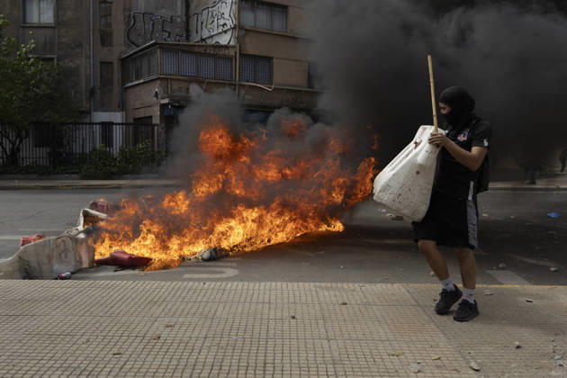 October 19, 2026, Santiago, Chile: A man walks past a burning barricade during the demonstration. In the center of the capital of Chile, different incidents took place between demonstrators and the police. The riots were carried out during the commemoration of the 7 years after the social outcast that happened on October 18, 2019. Santiago Chile  - ZUMAs197 20261019_aaa_s197_001 Copyright: xSebastianxNancox