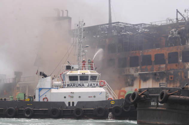 Efforts are underway to extinguish a fire that broke out on a passenger ferry in Indonesia s Cilegon PELABUHAN MERAK, CILEGON, INDONESIA - OCTOBER 21: Fireboats take turns spraying water onto the passenger ferry KMP Batumandi to cool down the vessel after it caught fire while preparing to dock off Merak Port in Cilegon, Banten, Indonesia on Wednesday, October 21, 2026. The vessel caught fire on Tuesday, October 20, and rescue operations remain underway as the ship continues to emit smoke. Water is continuously sprayed to cool the vehicle deck containing numerous cars, motorcycles, buses, and trucks, while authorities confirm no fatalities have been reported. Dasril Roszandi Anadolu Pelabuhan Merak Indonesia. Editorial use only. Please get Copyright: x2026xAnadoluxDasrilxRoszandix