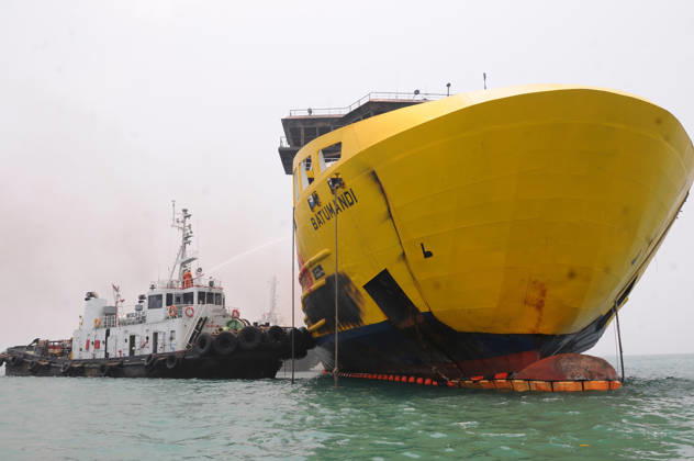 Efforts are underway to extinguish a fire that broke out on a passenger ferry in Indonesia s Cilegon PELABUHAN MERAK, CILEGON, INDONESIA - OCTOBER 21: Fireboats take turns spraying water onto the passenger ferry KMP Batumandi to cool down the vessel after it caught fire while preparing to dock off Merak Port in Cilegon, Banten, Indonesia on Wednesday, October 21, 2026. The vessel caught fire on Tuesday, October 20, and rescue operations remain underway as the ship continues to emit smoke. Water is continuously sprayed to cool the vehicle deck containing numerous cars, motorcycles, buses, and trucks, while authorities confirm no fatalities have been reported. Dasril Roszandi Anadolu Pelabuhan Merak Indonesia. Editorial use only. Please get Copyright: x2026xAnadoluxDasrilxRoszandix