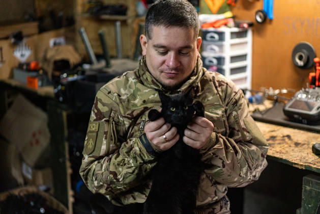 Ukrainian drone unit Skymonsters upgrades heavy UAVs in Kharkiv region KHARKIV REGION, UKRAINE - OCTOBER 21: A serviceman plays with a cat as members of Skymonsters, the drone unit of the 13th Khartiia Brigade of Ukraine s National Guard, assemble, upgrade, and repair large unmanned aerial vehicles at an undisclosed location in Kharkiv region, Ukraine, on October 21, 2026. The drones, including Vampire models used for logistics missions and heavy bombers capable of carrying 13 to 20 kilograms of explosives, are prepared here before deployment to frontline positions. Carlo Bravo Anadolu Kharkiv Ukraine. Editorial use only. Please get in touch for any other usage.  Copyright: x2026xAnadoluxCarloxBravox