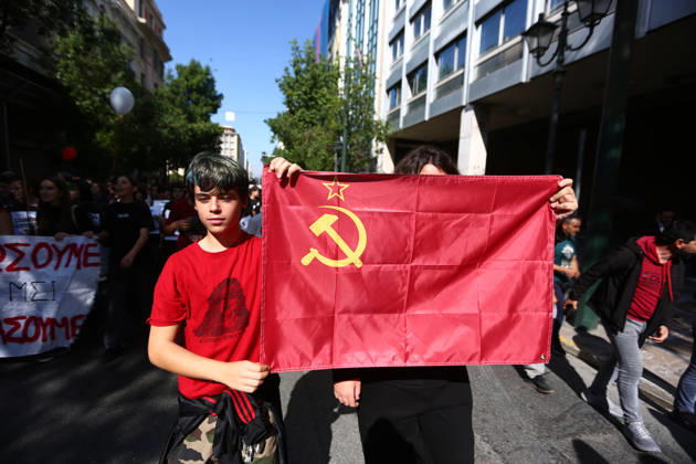 October 21, 2026, Athens, Attica, GREECE: A young demonstrator carries a red flag bearing the hammer and sickle during the mass education protest. Athens GREECE - ZUMAx103 20261021_zip_x103_017 Copyright: xHarrisxXanthopoulosx