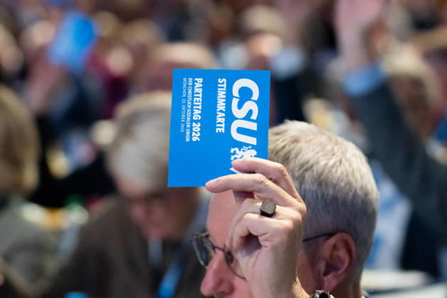 Munich, Bavaria, Germany October 23, 2026: The 2026 convention of the CSU (Christian Social Union) at the Munich Trade Fair Center. A hand holds a voting card aloft