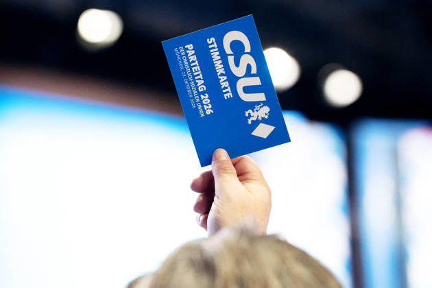 Munich, Bavaria, Germany - October 23, 2026: The 2026 party convention of the CSU (Christian Social Union) at the Munich Trade Fair Center. A hand holds a CSU voting card aloft; voting, cast a vote, vote, casting a vote