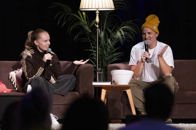 Poet and author Clara LOESEL LÖSEL (left) in conversation with author and podcaster Lars AMEND (right) during her reading—a preview event for her new book, *Ich dachte, sowas fühle nur ich*—sitting on sofas with microphones at the Theater am Tanzbrunnen, Cologne, on October 23, 2026