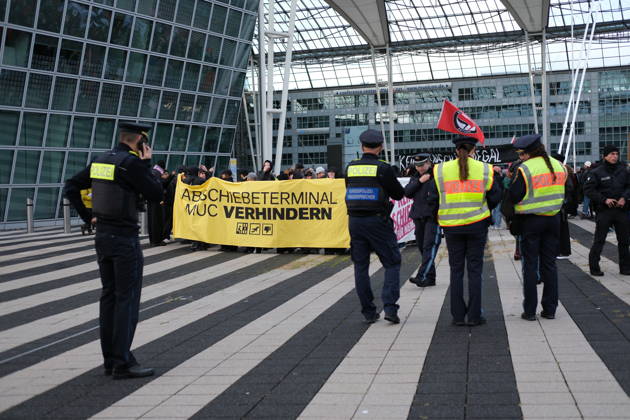 Protest at Munich Airport against planned deportation terminal MUNICH, GERMANY - OCTOBER 24: Police officers stand in front of protesters holding a yellow banner reading Abschiebeterminal MUC verhindern (Stop the MUC Deportation Terminal) during a demonstration outside the MAC Forum at Munich Airport in Munich, Germany on October 24, 2026. The rally targets a planned deportation terminal that Germany s federal government intends to operate at the airport from 2028. Merve Goettl Anadolu Munich Germany. Editorial use only. Please get in touch for any other usage.  Copyright: x2026xAnadoluxMervexGoettlx