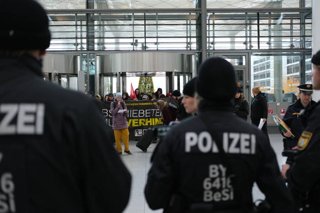 Protest at Munich Airport against planned deportation terminal MUNICH, GERMANY - OCTOBER 24: Police officers stand facing protesters holding a banner reading Abschiebeterminal muss verhindert werden (Deportation terminal must be prevented) inside the MAC Forum at Munich Airport in Munich, Germany on October 24, 2026. The demonstration targets a planned deportation terminal that Germany s federal government intends to operate at the airport from 2028. Merve Goettl Anadolu Munich Germany. Editorial use only. Please get in touch for any other usage.  Copyright: x2026xAnadoluxMervexGoettlx