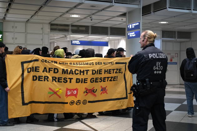 Protest at Munich Airport against planned deportation terminal MUNICH, GERMANY - OCTOBER 24: Protesters hold a banner reading Die AFD macht die Hetze, der Rest die Gesetze (The AfD does the incitement, the rest make the laws) during a demonstration against a planned deportation terminal at Munich Airport in Munich, Germany on October 24, 2026. The banner also displays crossed-out logos of several German political parties. Merve Goettl Anadolu Munich Germany. Editorial use only. Please get in touch for any other usage.  Copyright: x2026xAnadoluxMervexGoettlx