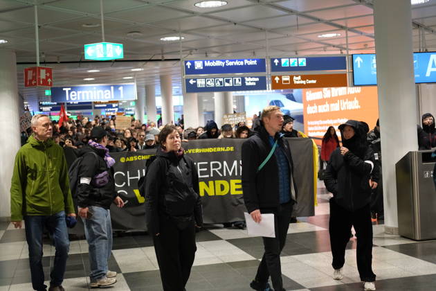 Protest at Munich Airport against planned deportation terminal MUNICH, GERMANY - OCTOBER 24: Protesters march through Terminal 1 at Munich Airport carrying a banner reading Abschiebeterminal MUC verhindern (Stop the MUC Deportation Terminal) during a demonstration against a planned deportation terminal in Munich, Germany on October 24, 2026. The campaign, backed by the Bavarian Refugee Council and other organizations, opposes the federal government s plans to process mass deportations at the airport from 2028. Merve Goettl Anadolu Munich Germany. Editorial use only. Please get in touch for any other usage.  Copyright: x2026xAnadoluxMervexGoettlx