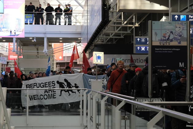 Protest at Munich Airport against planned deportation terminal MUNICH, GERMANY - OCTOBER 24: Protesters carry a banner reading Refugees Are Welcome and red flags through the terminal of Munich Airport as police officers watch from an upper level in Munich, Germany on October 24, 2026. The demonstration targets a planned deportation terminal at the airport backed by Germany s federal government. Merve Goettl Anadolu Munich Germany. Editorial use only. Please get in touch for any other usage.  Copyright: x2026xAnadoluxMervexGoettlx
