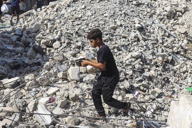 Gaza Palestinians Food Shortages 2026 A Palestinian boy carries a metal cooking pot while walking through rubble from destroyed buildings in Jabalia Refugee Camp, northern Gaza Strip, Palestine, on October 24, 2026. The UN reports that damaged infrastructure, displacement and shortages of basic supplies continue to affect residents of Gaza, while funding shortages have reduced food assistance. Jabalia Gaza Strip Palestinian Territories Copyright: xRamezxHabboubx