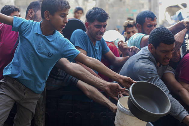 Gaza Palestinians Food Shortages 2026 Palestinians press toward a charity kitchen carrying pots and bowls to receive hot food in Jabalia Refugee Camp, northern Gaza Strip, Palestine, on October 24, 2026. Community kitchens remain a key source of food in Gaza, where UN humanitarian agencies reported cuts to cooked-meal distributions in October because of funding shortages. Jabalia Gaza Strip Palestinian Territories Copyright: xRamezxHabboubx