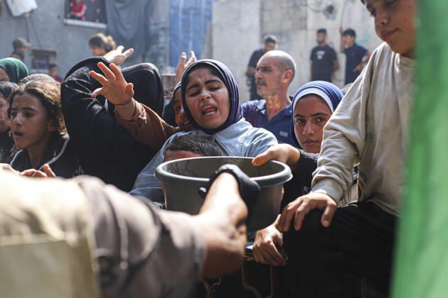 Gaza Palestinians Food Shortages 2026 Palestinian women reach forward as food is handed out at a charity kitchen in Jabalia Refugee Camp, northern Gaza Strip, Palestine, on October 24, 2026. Community kitchens remain a key source of food in Gaza, where UN humanitarian agencies reported cuts to cooked-meal distributions in October because of funding shortages. Jabalia Gaza Strip Palestinian Territories Copyright: xRamezxHabboubx