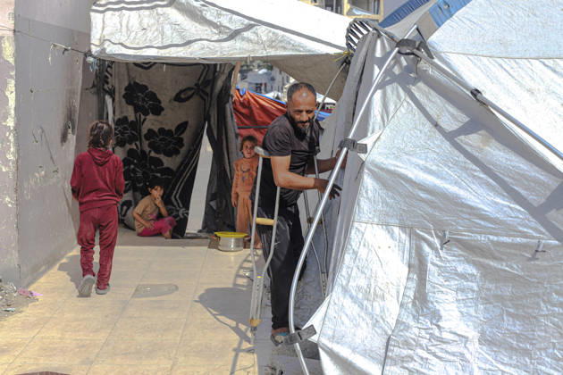 Gaza Palestinians Food Shortages 2026 A Palestinian man using crutches stands beside a makeshift shelter with children after receiving food from a charity kitchen in Jabalia Refugee Camp, northern Gaza Strip, Palestine, on October 24, 2026. Families continue to rely on hot meal distributions amid severe food shortages, widespread destruction and limited access to essential supplies across Gaza. Jabalia Gaza Strip Palestinian Territories Copyright: xRamezxHabboubx