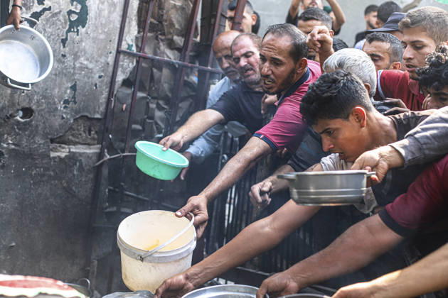 Gaza Palestinians Food Shortages 2026 Palestinians press toward a charity kitchen carrying pots and bowls to receive hot food in Jabalia Refugee Camp, northern Gaza Strip, Palestine, on October 24, 2026. Community kitchens remain a key source of food in Gaza, where UN humanitarian agencies reported cuts to cooked-meal distributions in October because of funding shortages. Jabalia Gaza Strip Palestinian Territories Copyright: xRamezxHabboubx