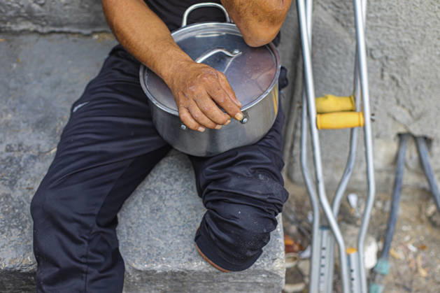 Gaza Palestinians Food Shortages 2026 A Palestinian man rests a metal cooking pot on his lap beside a pair of crutches in Jabalia Refugee Camp, northern Gaza Strip, Palestine, on October 24, 2026. The UN says widespread damage, displacement and food shortages have left families across Gaza heavily dependent on humanitarian assistance, with food distributions reduced in October amid funding constraints. Jabalia Gaza Strip Palestinian Territories Copyright: xRamezxHabboubx