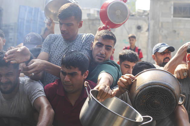Gaza Palestinians Food Shortages 2026 Palestinians press toward a charity kitchen carrying pots and bowls to receive hot food in Jabalia Refugee Camp, northern Gaza Strip, Palestine, on October 24, 2026. Community kitchens remain a key source of food in Gaza, where UN humanitarian agencies reported cuts to cooked-meal distributions in October because of funding shortages. Jabalia Gaza Strip Palestinian Territories Copyright: xRamezxHabboubx