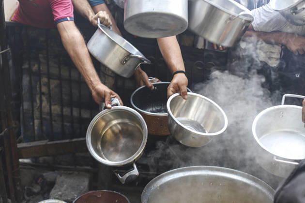 Gaza Palestinians Food Shortages 2026 Hands hold several metal bowls over steaming cooking pots during a hot meal distribution in Jabalia Refugee Camp, northern Gaza Strip, Palestine, on October 24, 2026. Community kitchens remain a key source of food in Gaza, where UN humanitarian agencies reported cuts to cooked-meal distributions in October because of funding shortages. Jabalia Gaza Strip Palestinian Territories Copyright: xRamezxHabboubx