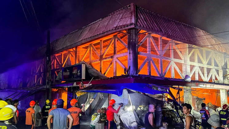 (261025) -- SORSOGON, Oct. 25, 2026 -- People gather outside a burning public market in Sorsogon city of southern Luzon, the Philippines, on Oct. 25, 2026. Five people have been confirmed dead after a fire in a public market here on Saturday night, local media reported Sunday. ( Handout via Xinhua) (SpotNews) PHILIPPINES-SORSOGON-PUBLIC MARKET-FIRE SorsogonxPublicxInformationxOffice 