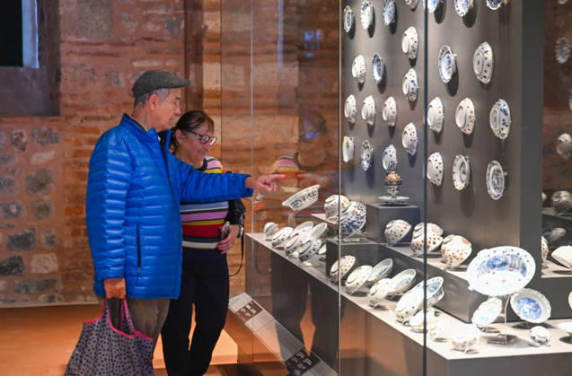 (261025) -- ISTANBUL, Oct. 25, 2026 -- Visitors view Chinese porcelain exhibits at the newly opened Porcelain Museum within the Topkapi Palace in Istanbul, T¨¹rkiye, Oct. 25, 2026. T¨¹rkiye on Saturday inaugurated a new museum district within Istanbul s historic Topkapi Palace, where thousands of Chinese porcelain pieces are on display, reflecting centuries of cultural exchanges between China and T¨¹rkiye. Restored into a historical neighborhood complete with its own streets and squares, the palace s former mint now houses the Porcelain Museum, which displays 5,300 pieces -- including 3,500 Chinese porcelains -- across 19 halls. Dating back to the 13th century, Chinese porcelains -- particularly those from Jingdezhen -- traveled a