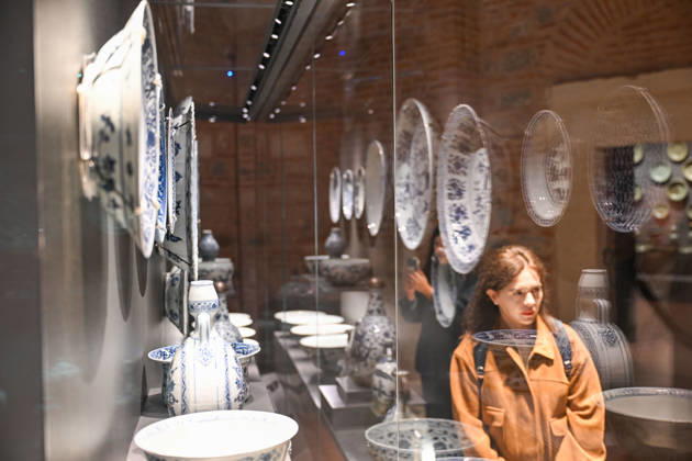 (261025) -- ISTANBUL, Oct. 25, 2026 -- A visitor views Chinese porcelain exhibits at the newly opened Porcelain Museum within the Topkapi Palace in Istanbul, T¨¹rkiye, Oct. 25, 2026. T¨¹rkiye on Saturday inaugurated a new museum district within Istanbul s historic Topkapi Palace, where thousands of Chinese porcelain pieces are on display, reflecting centuries of cultural exchanges between China and T¨¹rkiye. Restored into a historical neighborhood complete with its own streets and squares, the palace s former mint now houses the Porcelain Museum, which displays 5,300 pieces -- including 3,500 Chinese porcelains -- across 19 halls. Dating back to the 13th century, Chinese porcelains -- particularly those from Jingdezhen -- traveled