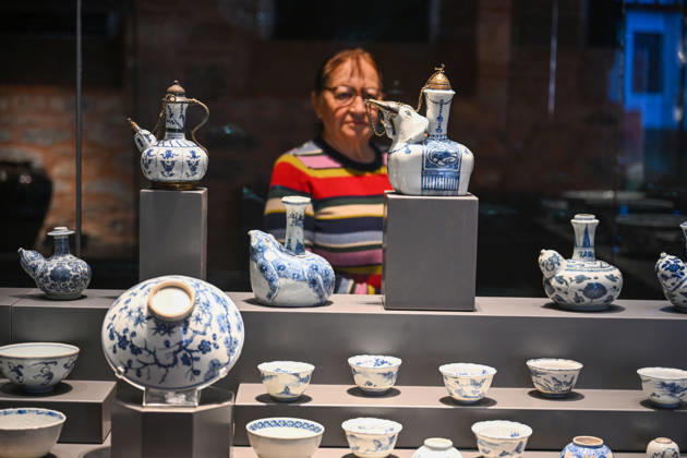 (261025) -- ISTANBUL, Oct. 25, 2026 -- A visitor views Chinese porcelain exhibits at the newly opened Porcelain Museum within the Topkapi Palace in Istanbul, T¨¹rkiye, Oct. 25, 2026. T¨¹rkiye on Saturday inaugurated a new museum district within Istanbul s historic Topkapi Palace, where thousands of Chinese porcelain pieces are on display, reflecting centuries of cultural exchanges between China and T¨¹rkiye. Restored into a historical neighborhood complete with its own streets and squares, the palace s former mint now houses the Porcelain Museum, which displays 5,300 pieces -- including 3,500 Chinese porcelains -- across 19 halls. Dating back to the 13th century, Chinese porcelains -- particularly those from Jingdezhen -- traveled
