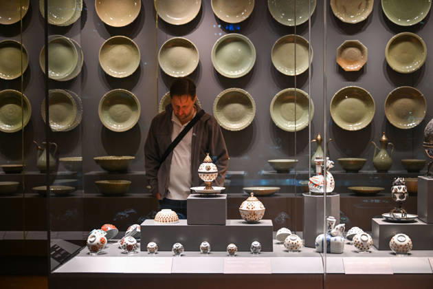 (261025) -- ISTANBUL, Oct. 25, 2026 -- A visitor views Chinese porcelain exhibits at the newly opened Porcelain Museum within the Topkapi Palace in Istanbul, T¨¹rkiye, Oct. 25, 2026. T¨¹rkiye on Saturday inaugurated a new museum district within Istanbul s historic Topkapi Palace, where thousands of Chinese porcelain pieces are on display, reflecting centuries of cultural exchanges between China and T¨¹rkiye. Restored into a historical neighborhood complete with its own streets and squares, the palace s former mint now houses the Porcelain Museum, which displays 5,300 pieces -- including 3,500 Chinese porcelains -- across 19 halls. Dating back to the 13th century, Chinese porcelains -- particularly those from Jingdezhen -- traveled
