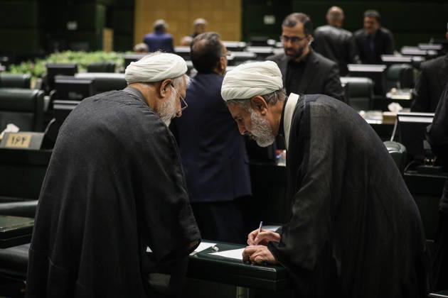 October 25, 2026, Tehran, Iran: Two white-turbaned clerics lean over a parliamentary desk and examine a document as a man stands behind them at the Islamic Consultative Assembly in Tehran, Iran, on October 25, 2026. The Iranian parliament held a hybrid open sitting, with some lawmakers attending in the Tehran chamber and others participating remotely, according to parliamentary reports. Tehran Iran - ZUMAi98_ 20261025_zih_i98_032 Copyright: xIcanax