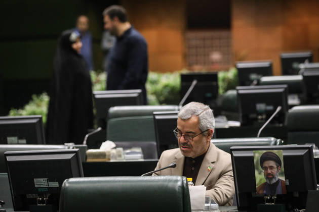 October 25, 2026, Tehran, Iran: A lawmaker in a beige jacket looks down at his parliamentary desk as a woman in a black chador talks to a man behind him at the Islamic Consultative Assembly in Tehran, Iran, on October 25, 2026. The Islamic Consultative Assembly resumed an open sitting in its Tehran chamber with a mix of in-person and remote participation, according to parliamentary reporting. Tehran Iran - ZUMAi98_ 20261025_zih_i98_046 Copyright: xIcanax